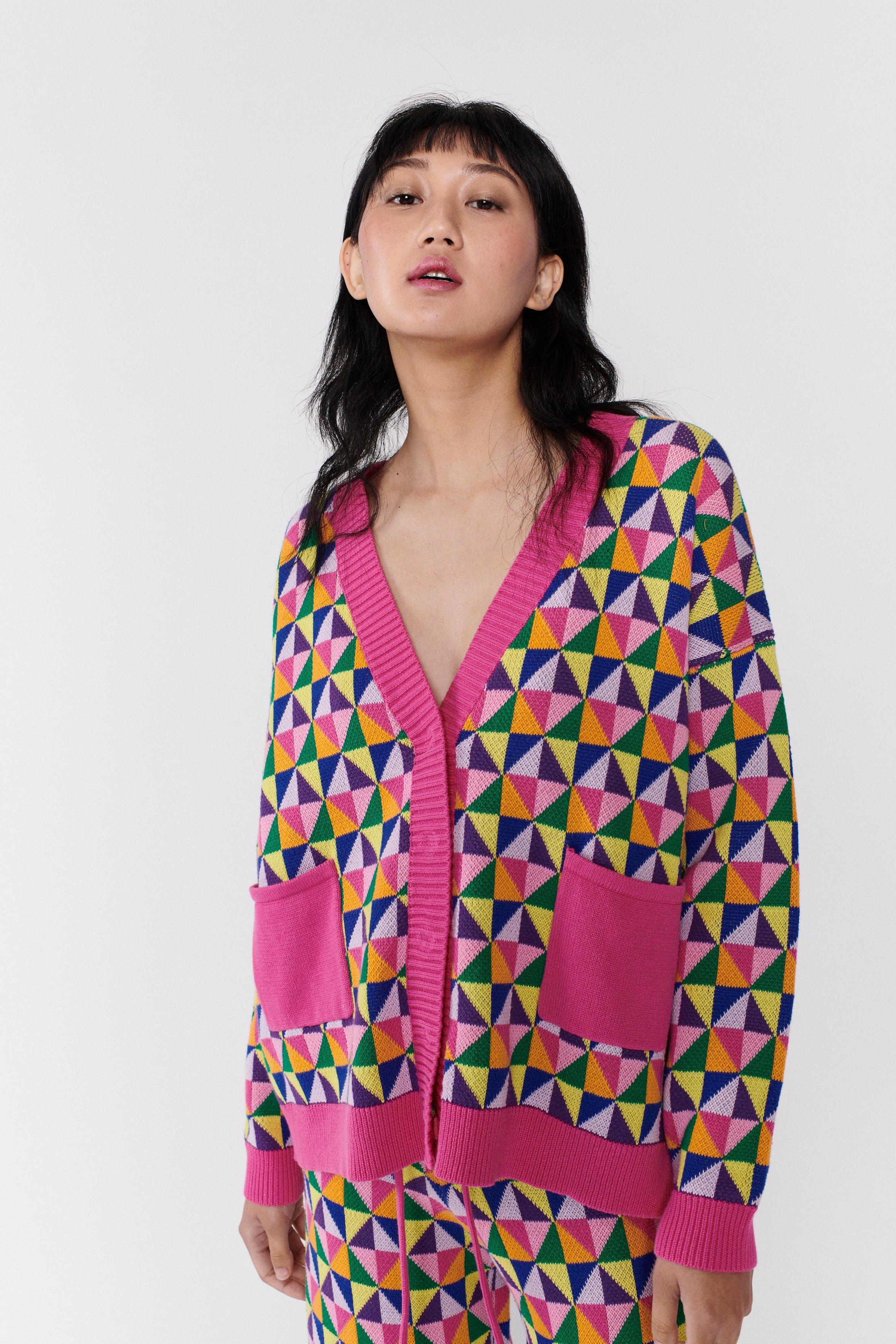 Model wears longline Magda longline cardigan in pink and multicolour origami pattern